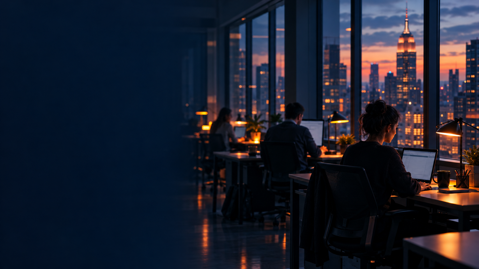 Team working late in a New York office with a dusk skyline behind floor-to-ceiling windows
